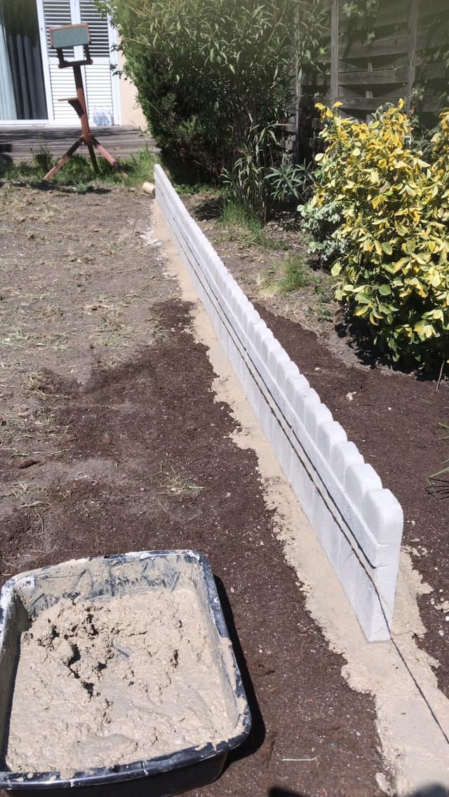 Bordure de jardin scellée au mortier le long d'un massif paillé