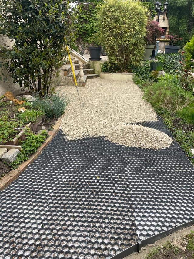 Remplissage en gravier des dalles stabilisatrices d'une allée de jardin